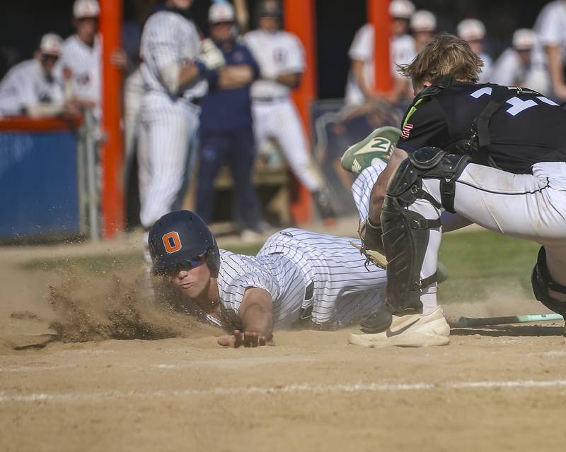 Oswego's Graham Schwab (2) slides safely into home during baseball game Oswego East at Oswego.  May 14, 2026 in Oswego.
