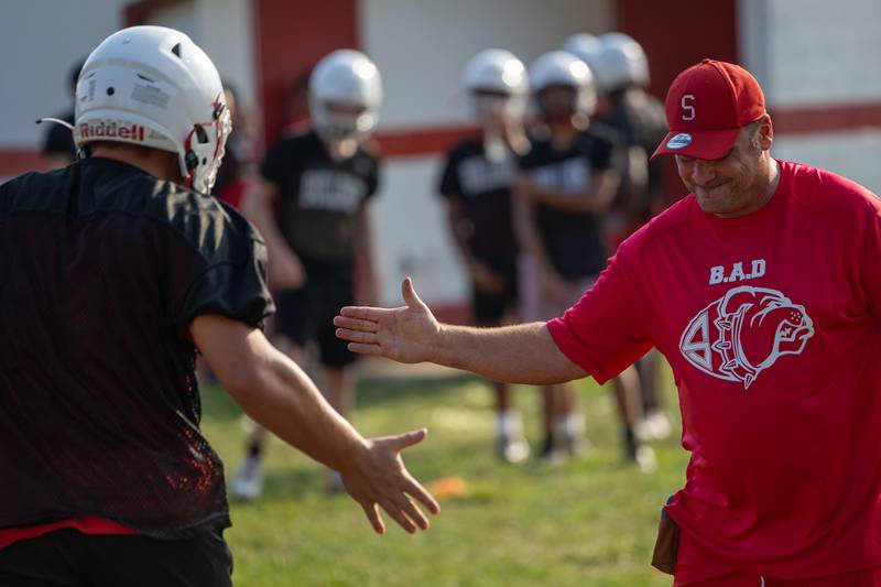 Coach Jason Schultz high fives player on Monday, August 11, 2025 at Streator High School in Streator.