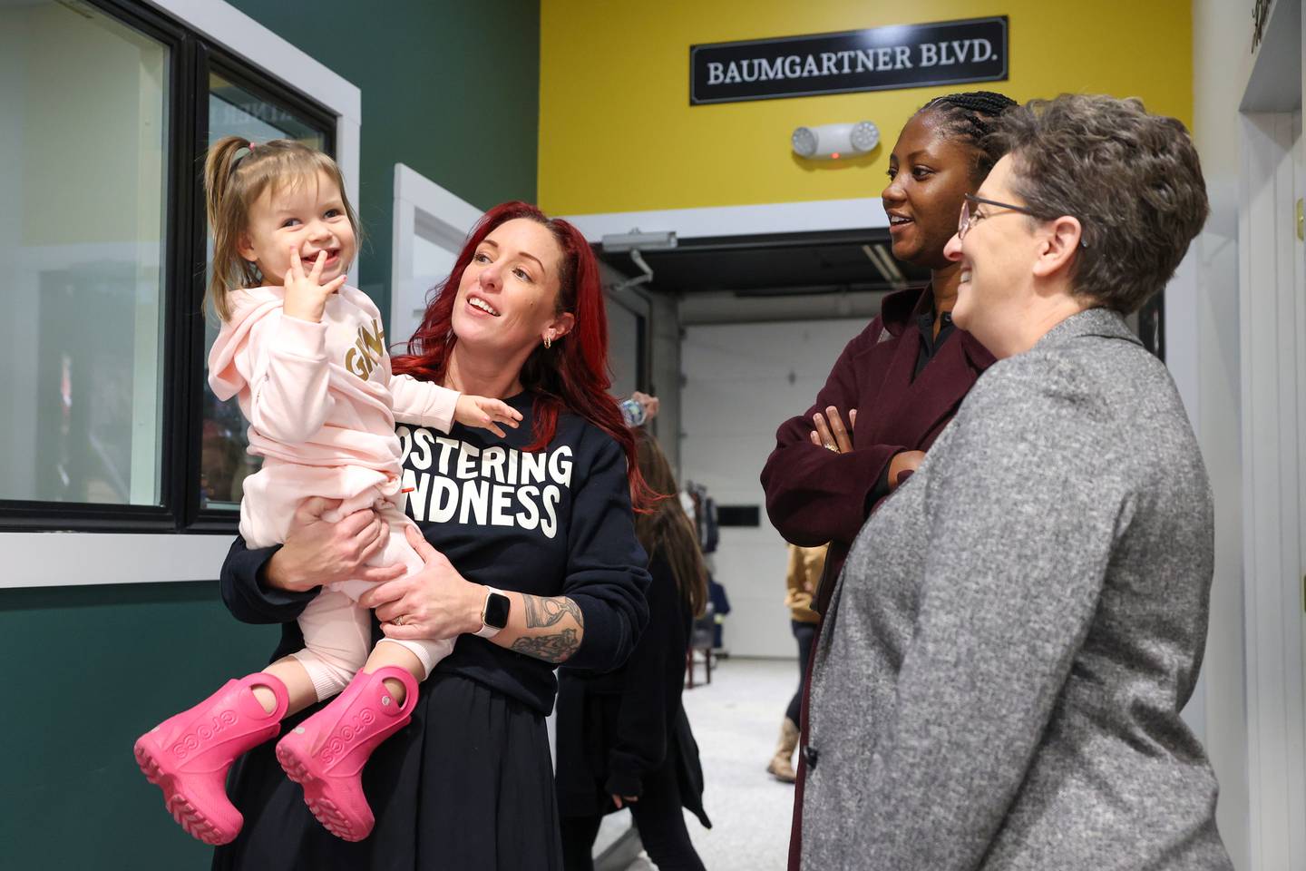 Georgie's Closet founder and President Rachel Langlois, left, holds her recently-adopted daughter and the not-for-profit’s namesake, Georgie, almost 3, as she chats with State Rep. Jackie Haas during the new location's grand opening on Bradley Blvd. in Bradley on Monday, Dec. 1, 2025.