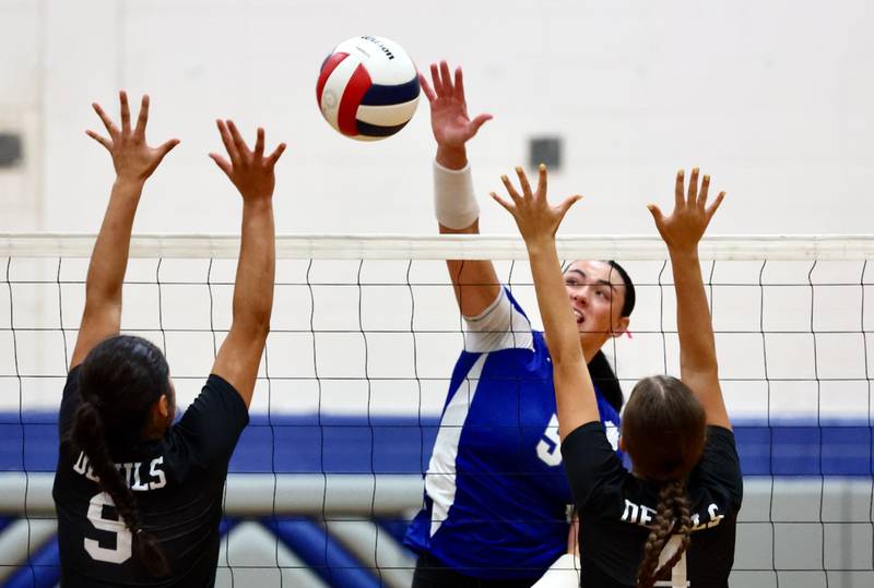 Princeton's Keely Davis hits the ball between Hall's Natalia Zamora (9) and Katharine Doll on Tuesday, Sept. 16, 2025 in Princeton.