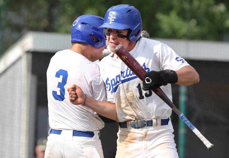 St. Francis' Luc Swiatek (right) celebrates after scoring the games first run with Trey Kiesler in their Class 3A regional semifinal against Sycamore Thursday, June 1, 2023, at Kaneland High School in Maple Park.