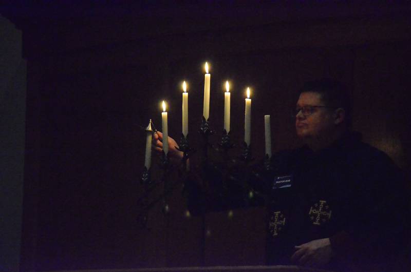 The Rev. Rob Hamilton, pastor at United Methodist Church of Geneva, extinguishes a candle during a Good Friday Tenebrae service. Pastors and members of Aurora and Batavia Methodist churches participated.