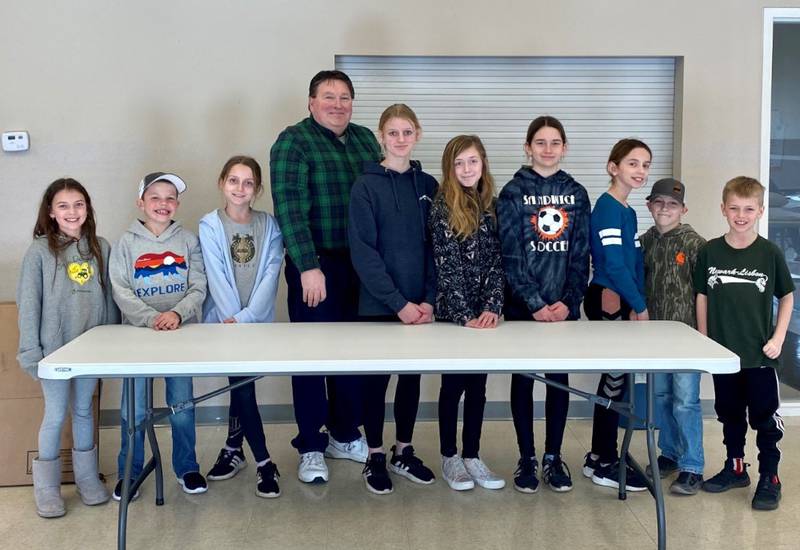 The Dream Catchers 4-H Club of Kendall County is pictured with Fox Township Supervisor Randy Seggebruch and one of the tables they donated to the township building.