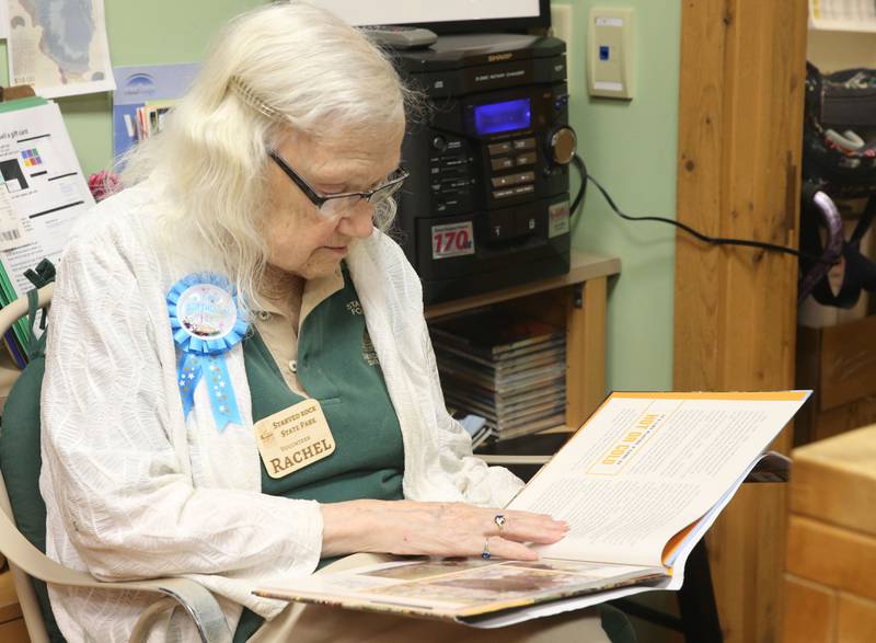 Rachel Mershon 94 of Granville, smiles while working behind the desk of the Starved Rock Bookstore on Monday, Sept. 22, 2025 inside the Starved Rock Visitors Center. Merschon, A former junior high teacher in Spring Valley, turned 94 years-old on Monday and the staff celebrated her birthday with cake and cupcakes. Merschon drives to the Visitors Center every Monday to volunteer at the park.