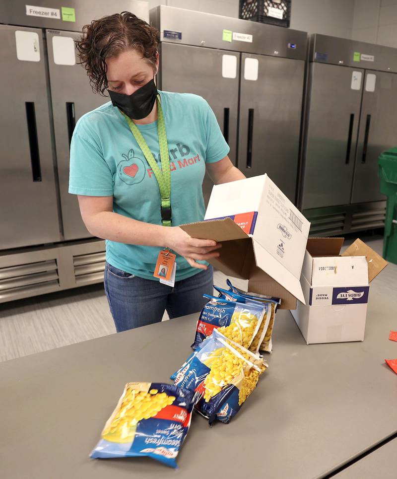 Joey Moore, director of Barb Food Mart, pours out frozen corn to put in the vegetarian bags Thursday, April 7, 2022, at the facility in DeKalb. Barb Food Mart is a food pantry serving those in need that have a student enrolled in the DeKalb School District.