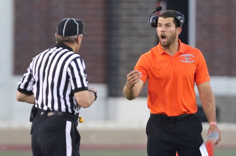 New DeKalb football head coach Derek Schneeman talks to an official Friday Aug. 27, 2021, during their game against Sycamore in the First National Challenge in Huskie Stadium at Northern Illinois University in DeKalb. Friday was the first game of the 2021 season for both schools.