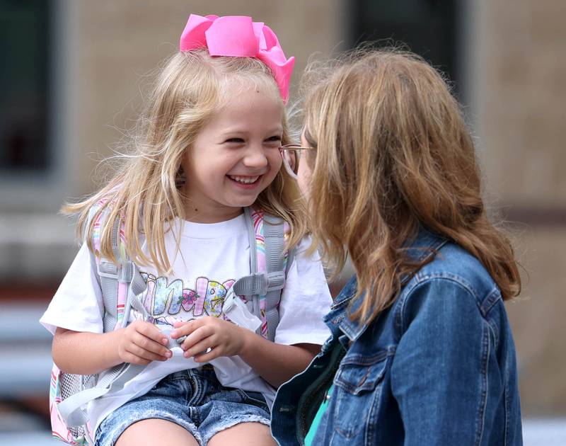 Kindergartener Sterling Smith talks to her mom Andrea as they wait for the doors to open Thursday, Aug. 21, 2025, for the first day of school at North Grove Elementary School in Sycamore.