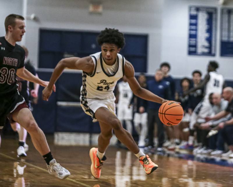 Oswego East's Dshaun Bolden (24) drives to the basket during their basketball game between Plainfield North at Oswego East Friday, Dec 5, 2025 in Oswego.