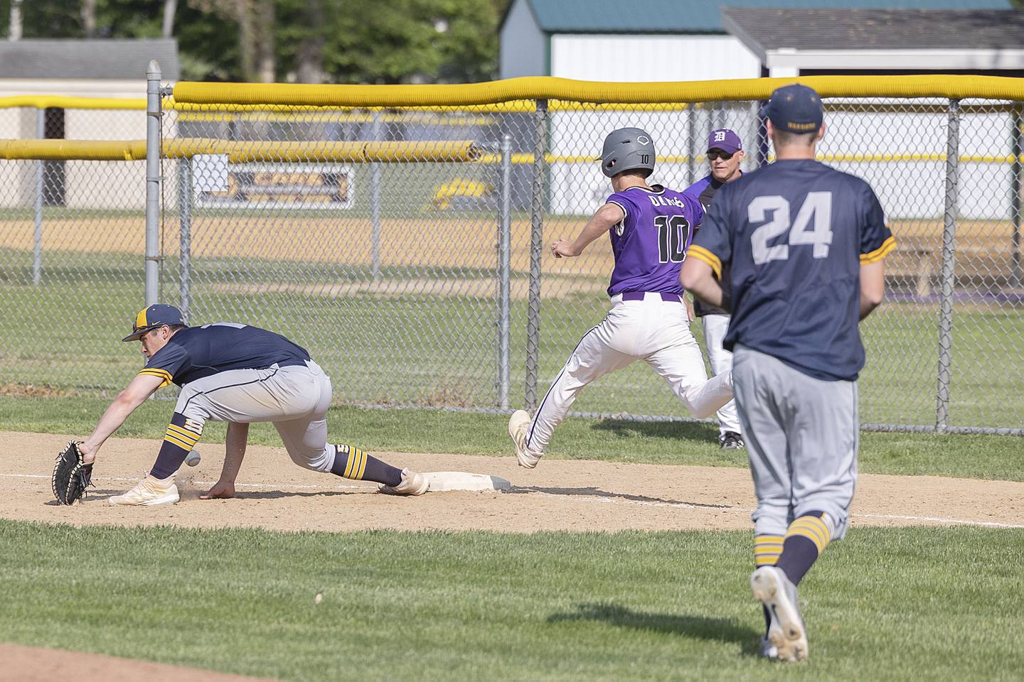 Sterling’s Mason Smithee is unable to grab a low throw at first as Dixon’s Bryce Feit makes it safely Tuesday, May 16, 2023.