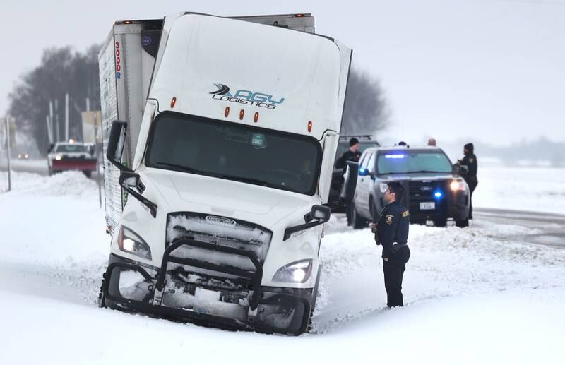 DeKalb and Kane County sheriff’s deputies respond to a semi-trailer truck in a ditch Friday, Jan. 12, 2024, at the intersection of Route 30 and County Line Road near Hinckley. Several inches of snow blanketed DeKalb County Friday on top of the 6 inches that fell on the area earlier this week.