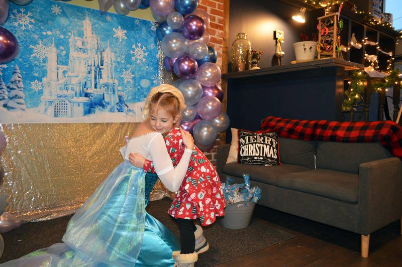 Amelia Heath, 5, of Polo, hugs Princess Elsa of "Frozen" at Marco's Nutrition in Polo on Saturday, Dec. 2, 2023. Marco's Nutrition was one stop during the fifth annual Polo Christmas Festival.