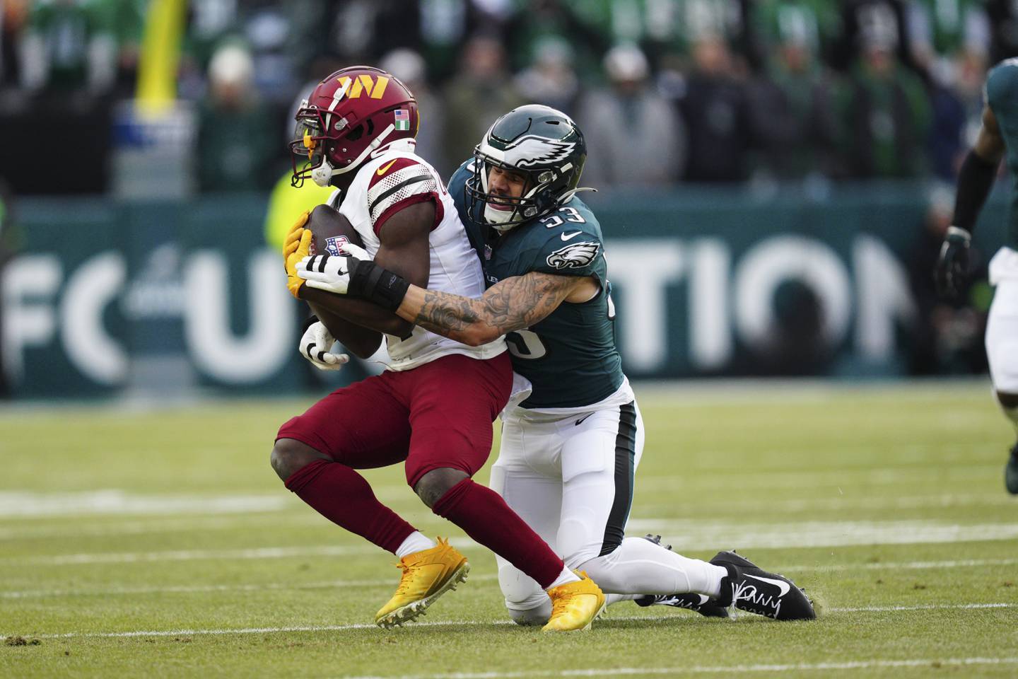 Washington Commanders wide receiver Olamide Zaccheaus, left, is tackled by Philadelphia Eagles linebacker Zack Baun (53) during the first half of the NFC Championship NFL football game, Sunday, Jan. 26, 2025, in Philadelphia. (AP Photo/Derik Hamilton)