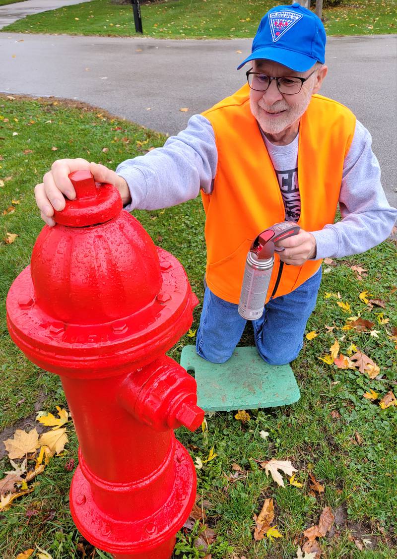 Spring Valley's Jim Dabler shows off his handy work, having helped the city by volunteering to scrape and paint all of the fire hydrants in the Webster Park neighborhood.