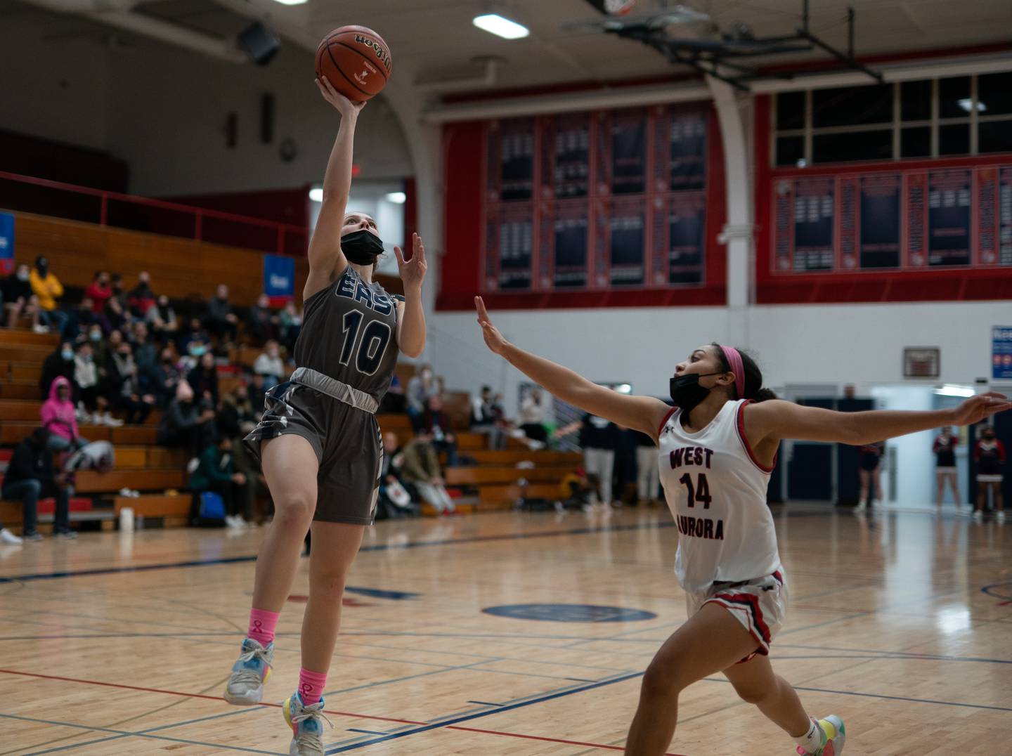 Oswego East's Madelyn Stockley (10) drives to the basket against West Aurora's Nia Evans (14) during a basketball game at West Aurora High School on Wednesday, Jan 26, 2022.