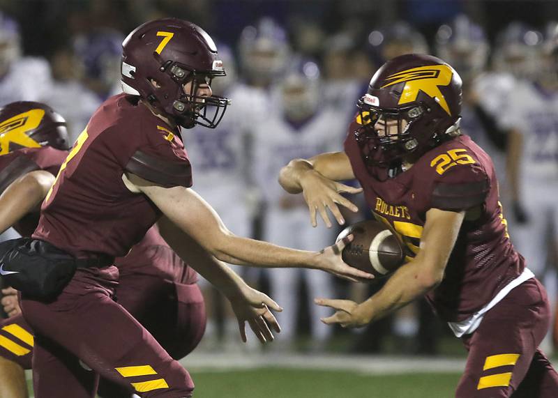 Richmond-Burton's JT Groh hands the ball of to running back Ryan Saranzak during a Kishwaukee River Conference football game against Rochelle on Friday, Oct.20, 2023, at Richmond-Burton High School.