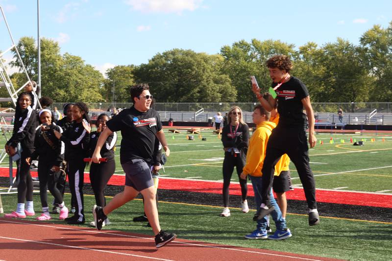 Bradley-Bourbonnais student Derek Otero nears the finish line in first place as a teammate hypes him up during the annual Boilermaker Games, hosted by the Best Buddies club on Wednesday, Oct. 8, 2025.