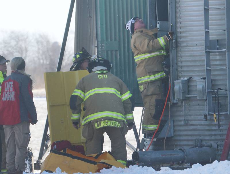Hennepin fire chief Quentin Buffington, (right) looks up the inside of a grain bin during a rescue on Monday, Jan. 26, 2026 in the 13000 block of North 950th Avenue just south of Granville. Two lifeflight helicopters laned and one victum was flown from the scene.