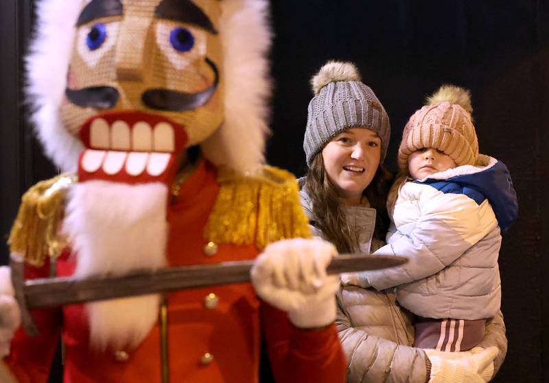 Natalie Searls and her niece Hazel Bolander, 3, from Genoa, watch a scene from “The Nutcracker” in front of Pizza. Beer. Whiskey. Friday, Nov. 22, 2024, during Moonlight Magic in downtown Sycamore.