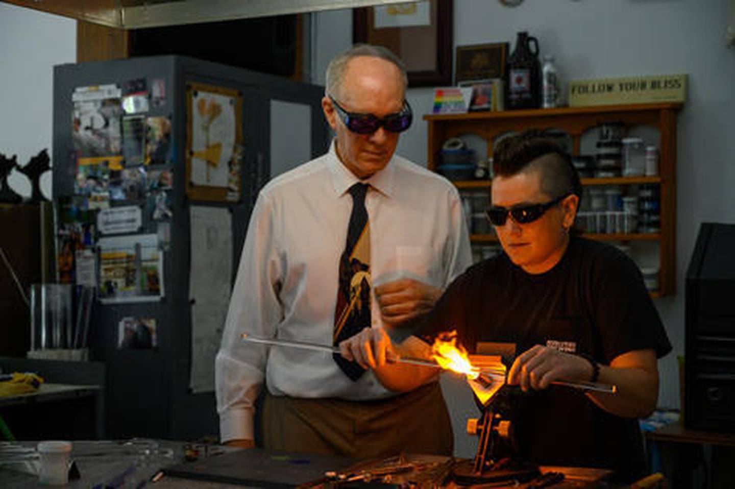 U.S. Rep. Bill Foster, D-Naperville works on the torch creating glass art with Sue Regis, owner of Regis Glass Art.