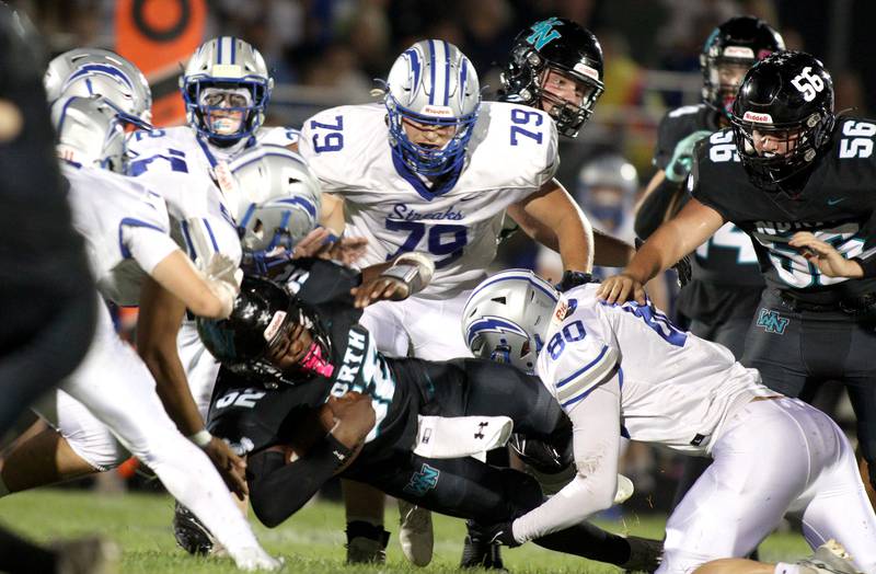 Woodstock North’s David Randecker is brought down by  Woodstock’s Edgar Arana in varsity football at Woodstock North Friday night. Closing in on the play is Woodstock’s Cooper Pajich (79) and Woodstock North’s Carter Brey (56)
