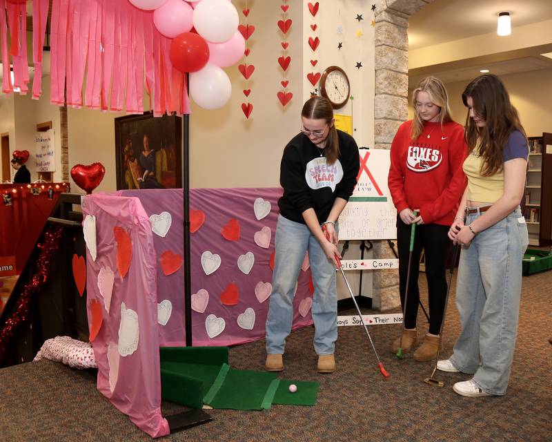 Ellie Fapp (left) tees of while Evelyn Obeirne and Claire Whaley watch at the Yorkville Public Library Mini Golf FUN Raiser on Sunday, Feb. 2, 2025 in Yorkville.