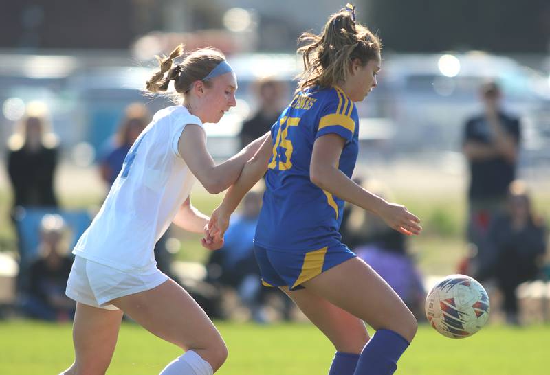 Johnsburg’s Lauren McQuiston, right, moves past Woodstock’s Lily Novelle in varsity soccer on Wednesday, April 23, 2025, at Johnsburg High School in Johnsburg.