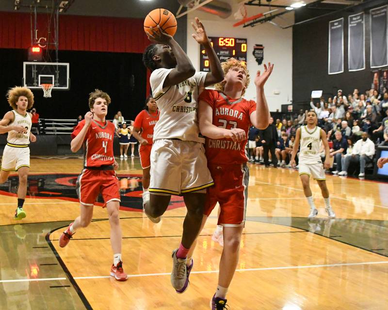 Indian Creek's Logan Schrader, left, takes a shot while being defended by Aurora Christian's Asa Johnson (23) during the regional title game on Friday Feb. 28, 2025, held at Indian Creek High School.