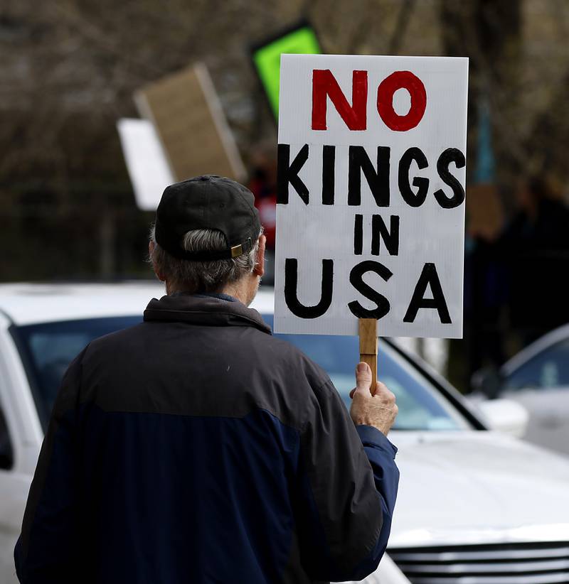 Protesters line U.S. Route 12 in Richmond to protest their discontent with President Donald Trump and his administration's policies on Saturday, April 19, 2025. Over 100, people took part in the Richmond protest. A second rally was held in Harvard later in the day.