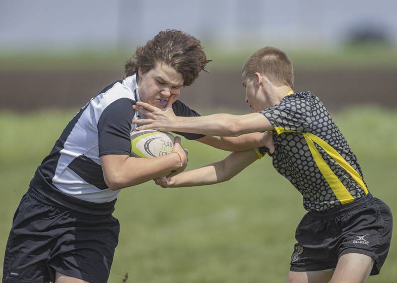 Will smith of the West Suburban Barbarians (left) protects the rugby ball against a defending player from the South Suburban Cobras Rugby Club at Veterans Park on April 28, 2024.
