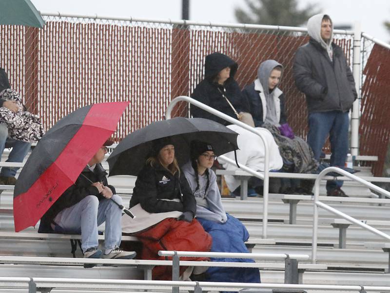 Fans try to keep dry as they wash McHenry and Richmond-Burton face off in a non-conference girls soccer match Thursday, March 16, 2023, at Richmond-Burton High. McHenry defeated Richmond Burton 4-0, in the first game of the season for both teams.
