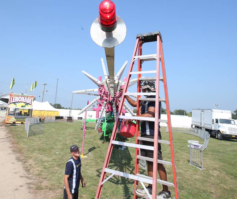 North American Midway Entertainment carnival workers replace light bulbs on a ride as they set up for the 168th annual Bureau County Fair on Tuesday, Aug. 22, 2023 in Princeton. The fair runs Wednesday through Sunday.