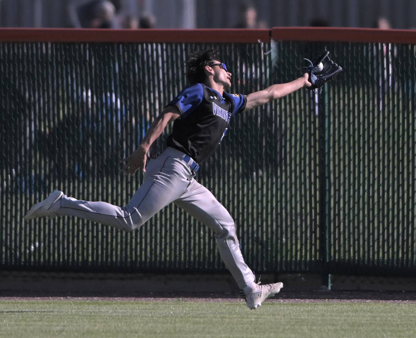 Geneva centerfielder Nick Lozano stretches on the run to catch a drive from St. Charles East’s Nathan Moline in a baseball game in St. Charles on Wednesday, May 20, 2026.