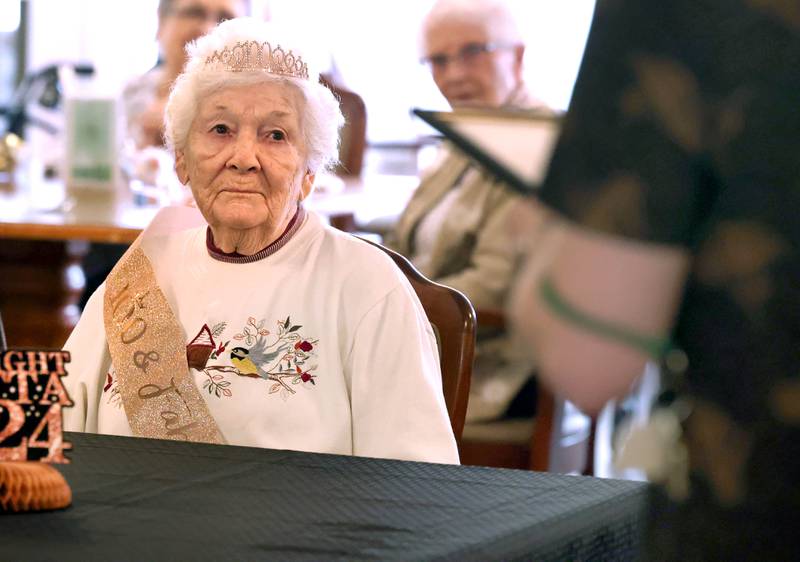 Heritage Woods of DeKalb resident Phyllis Fawcett, listens as a happy birthday letter from Gov. JB Pritzker is read during her surprise 100th birthday party Thursday, March 21, 2024, at Heritage Woods.
