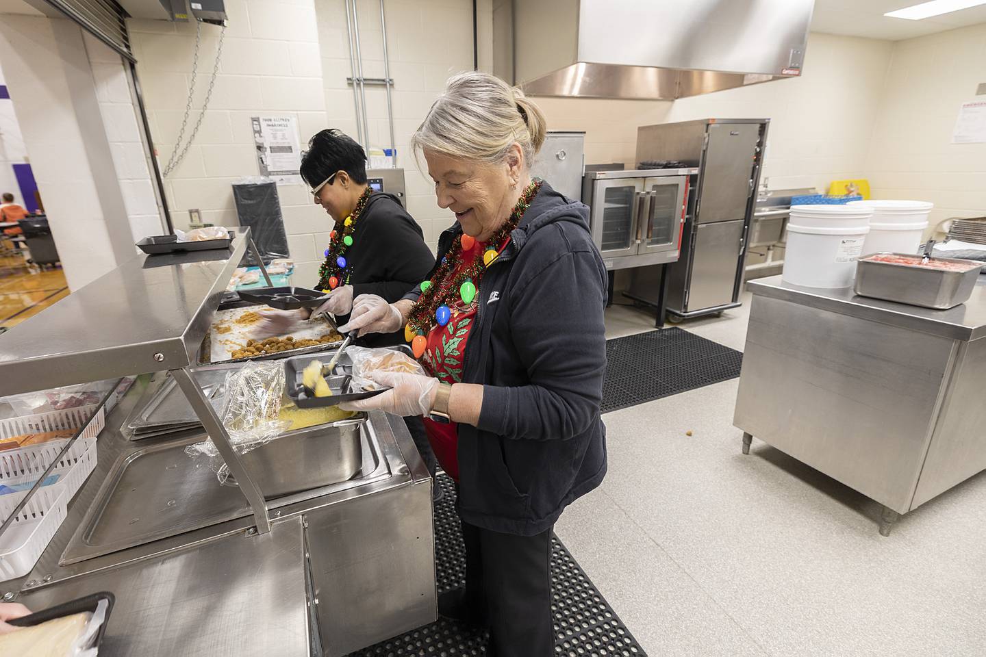 Priscilla Smith (left) and Sheila Brady serve lunches Tuesday, Dec. 17, 2024, at Jefferson School in Dixon. Destiny McElhinney of Dixon is leading a fundraiser with the goal of wiping out student lunch debt at the school.