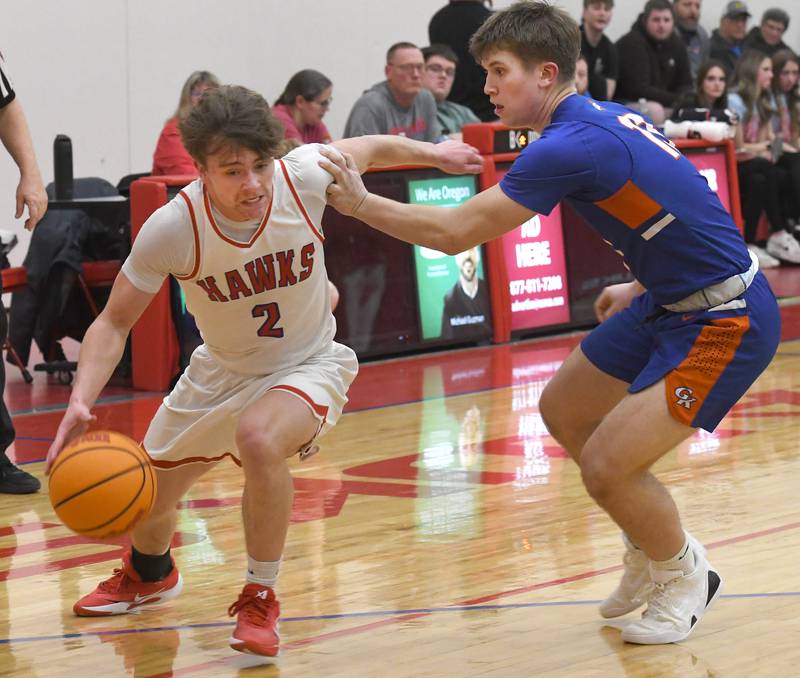 Oregon's Cooper Johnson drives to the basket as Genoa-Kingston's Conner Harney defends on Friday, Jan. 30, 2026 at the Blackhawk Center.