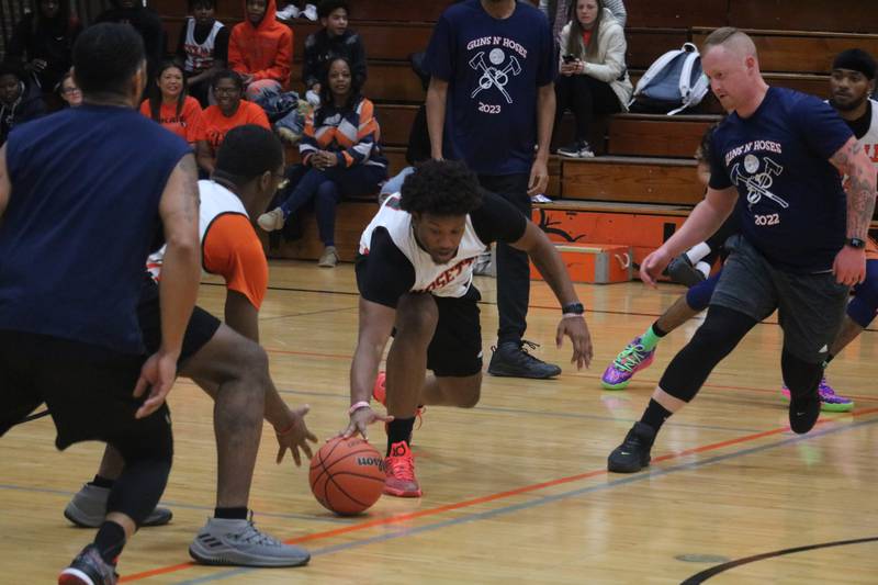 Jalon Redmond (center) scrambles for a loose ball Dec. 4, 2023 during the annual Guns and Hoses Basketball put on at Huntley Middle School in DeKalb.