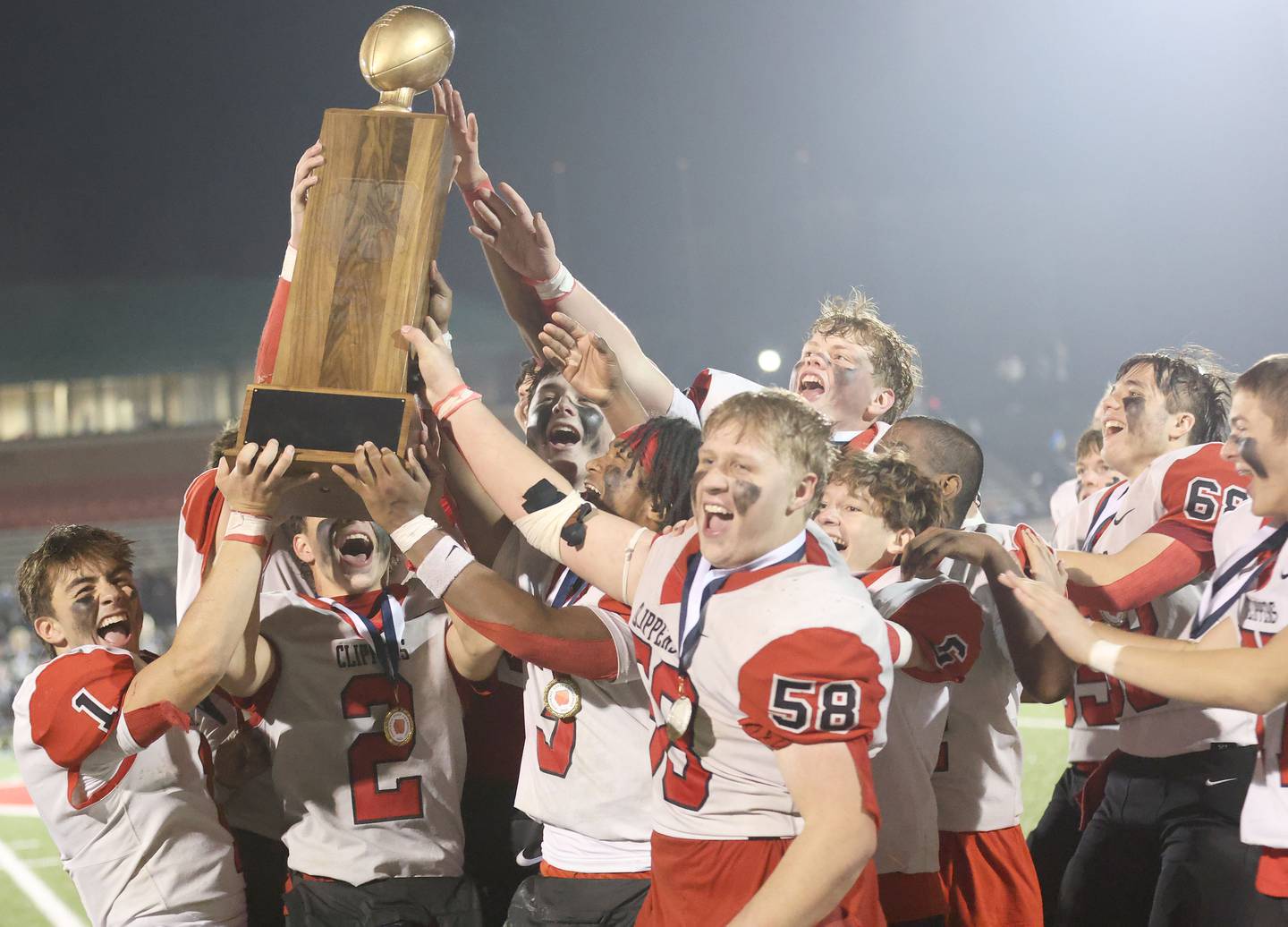 Members of the Amboy/LaMoille/Ohio football team hoist the 8-man I8FA championship trophy after defeating Polo 30-20 on Friday, Nov. 21, 2025 at April Zorn Memorial Stadium in Monmouth.