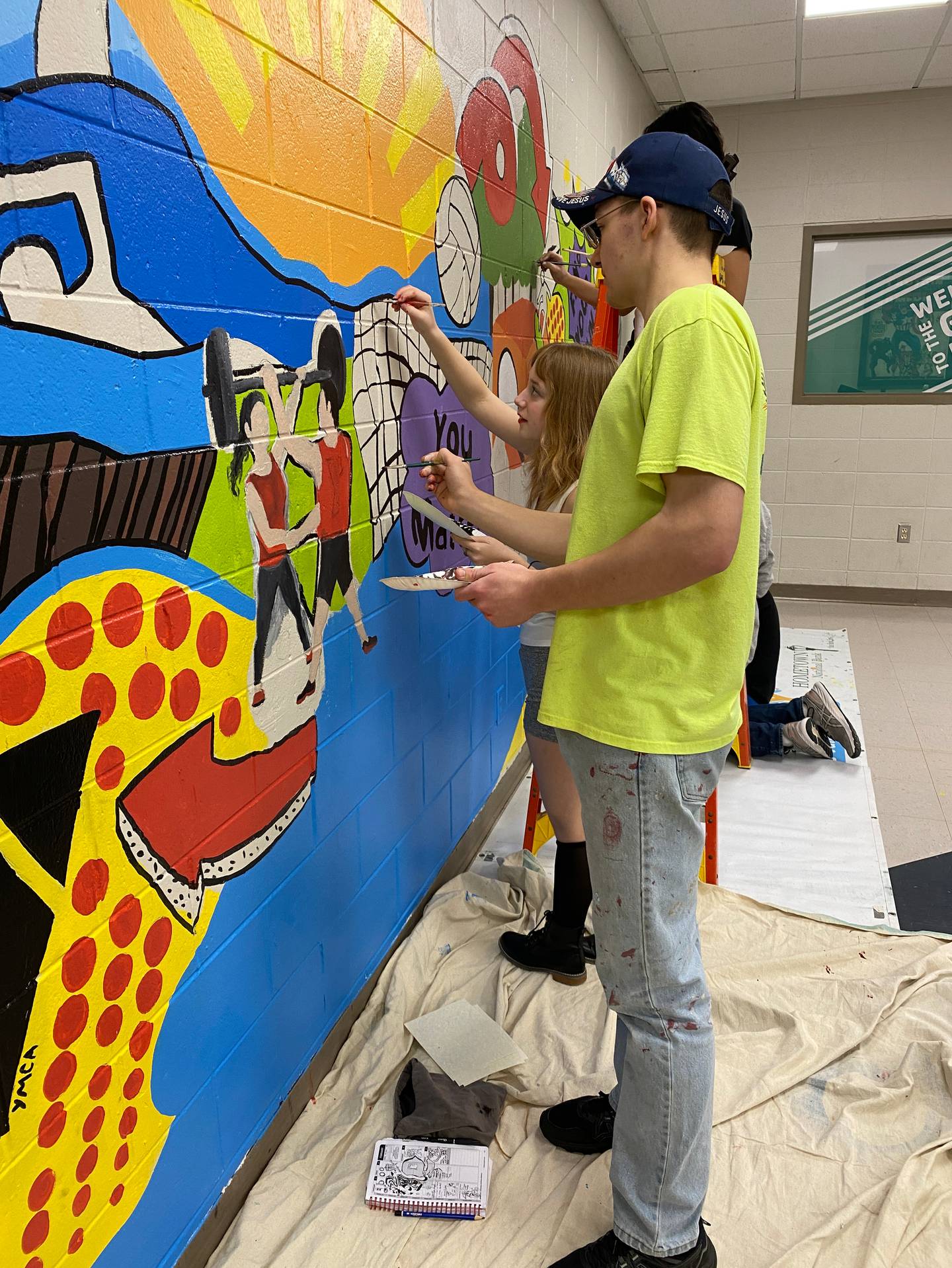 La Salle-Peru High School art students work on creating a mural for a blank wall at the Peru YMCA.