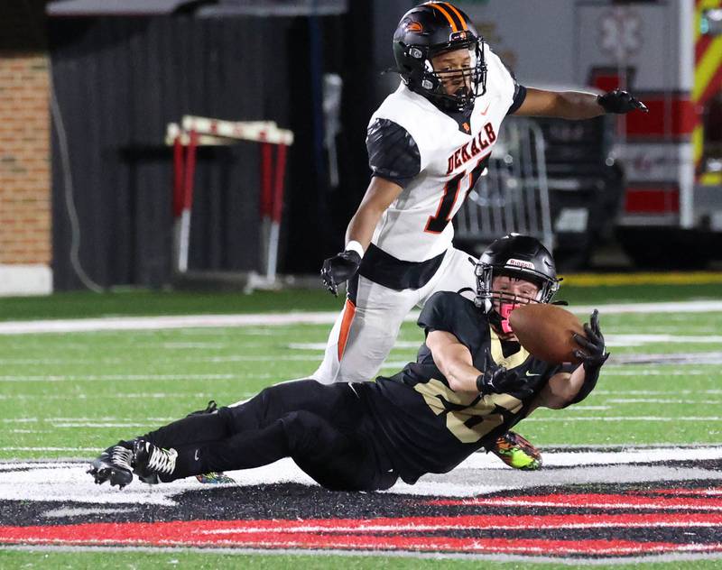 Sycamore's Caden Ralph makes a sliding catch in front of DeKalb's Jayden Rogers for a first down late in the game Friday, Aug. 29, 2025, during the FNBO Challenge in Huskie Stadium at Northern Illinois University.