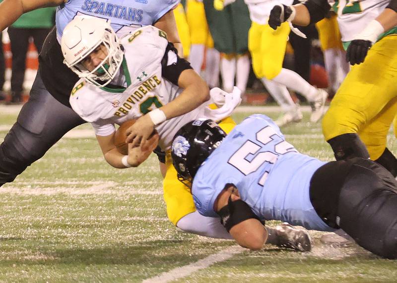 Providence Catholic quarterback Dominic Vita is sacked by St. Francis's Cooper Paukstis during the Class 5A State championship on Tuesday, Dec. 2, 2025 in Hancock Stadium at Illinois State University in Normal.