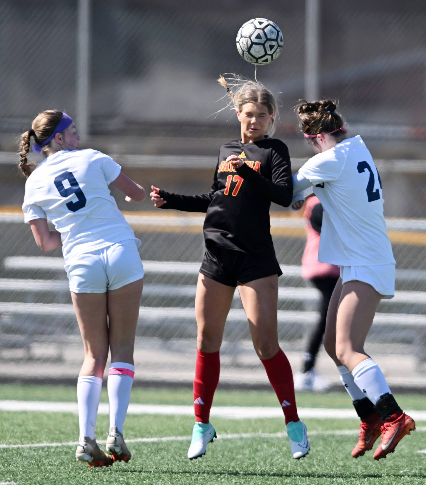 Batavia’s Natalie Warner jumps for a header between Oswego East’s Emma Klosterman, left, and Kailey Smith during a girls soccer match on Saturday, March 23, 2024 in Batavia.
