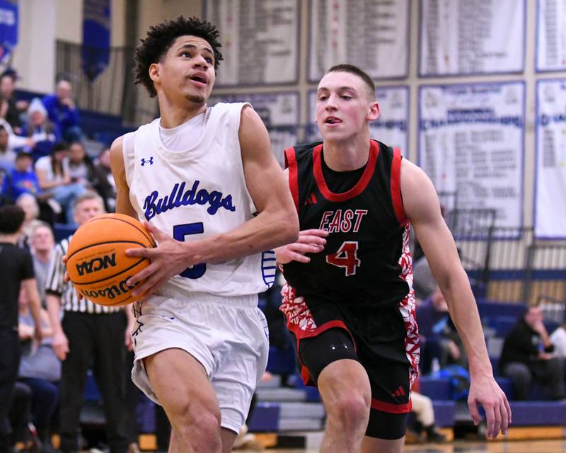 Riverside-Brookfield's Cameron Mercer, left, makes a basket while being defended by Glenbard East's Michael Nee (4) during the game on Tuesday Feb. 3, 2026, held at Riverside-Brookfield High School.