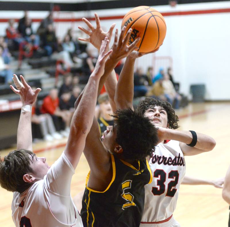 Riverdale's Aris Morgan (5) shoots as Forreston's Brandon Greenfield (0) and Jonathan Milnes (32) defend on Friday, Dec. 27, 2024 at the Cliff Warkins Memorial Basketball Tournament at Erie High School.