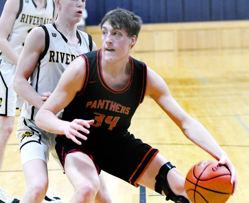 Erie-Prophetstown's Caleb Naftzger (34) makes a move to the basket as Riverdale's Jack Willems (2) defends during the championship of the 2A West Carroll Regional on Saturday, Feb. 25.