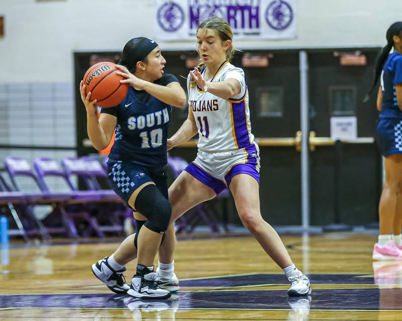 Downers Grove North's Abby Gross (11 defends Downers Grove South's Elizabeth Rous (10) during girls basketball game between Downers Grove South at Downers Grove North. Dec 16, 2023.