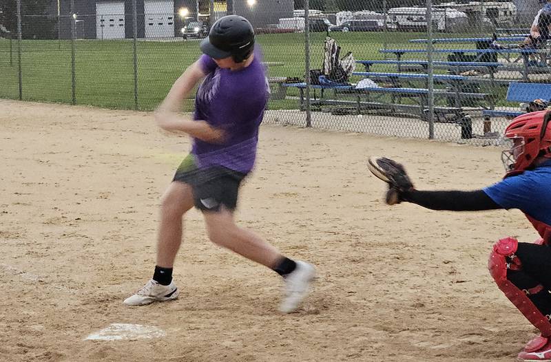 First Lutheran's Aidan Lange hits while St. Paul catcher Paul Garlisch looks on in a game on Monday, July 17, 2024.