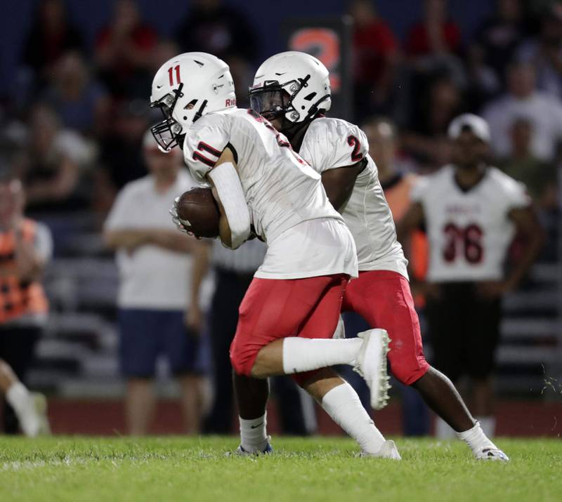 Brian Hill/bhill@dailyherald.com
Glenbard East Dillon Williams (2) hands the ball to John Seybold (11) Friday September 2, 2022 in South Elgin.