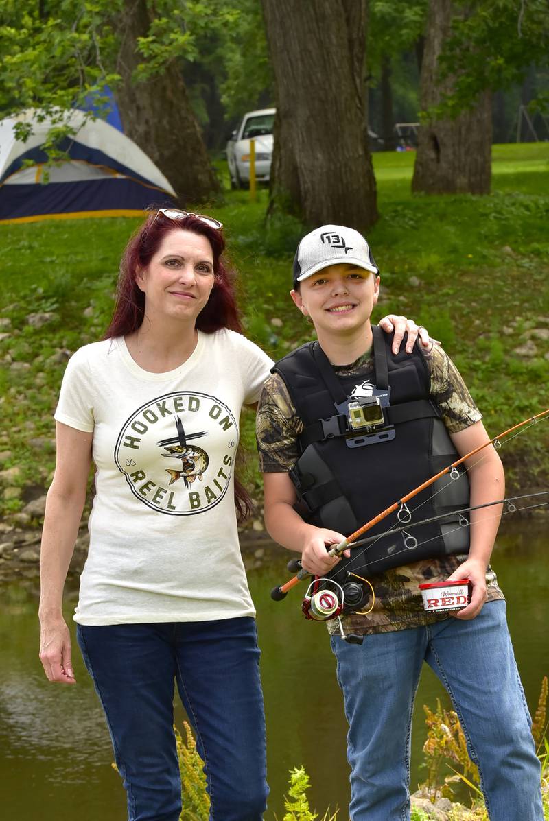 Thirteen year old angler and entrepreneur, Connor Jacobs,  poses with his mom,Julie, on Saturday, June 14, 2025 at the 19th annual Dick Brown Fishing Derby at Prophetstown State Park. Connor, who started his own bait company, Hooked On Reel Baits, came out Saturday morning sporting his life jacket and Go Pro camera. He wanted to set a good example to the younger anglers about the importance of safety near the water and he hoped to catch some "awesome footage" for his you tube channel.