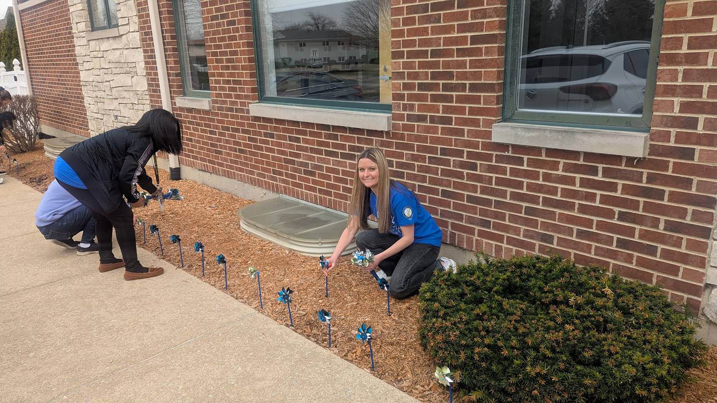 Taylor Sandeno, family advocate and prevention outreach coordinator at the Will County Children’s Advocacy Center in Crest Hill, plants blue pinwheels outside the center on Tuesday, April 1, 2025.