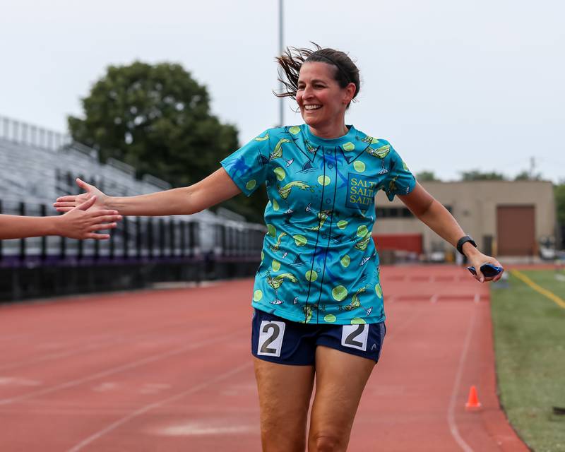 Amy Curran finishes the mile run's first heat at the community festival and running fundraiser for mental health awareness and suicide prevention in honor of Ben Silver.  July 23, 2022.